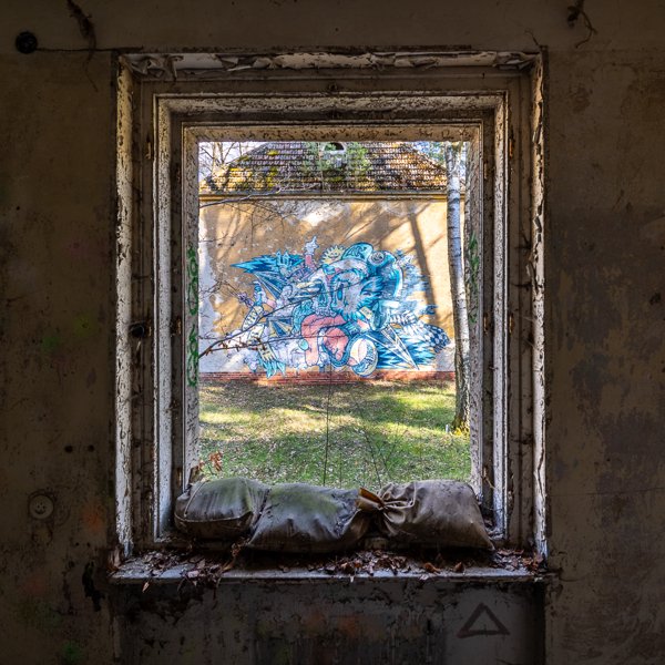 Graffiti seen through a sandbagged window