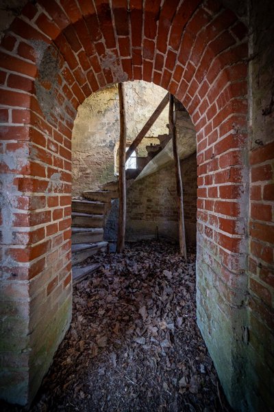 Spiral stair behind an arch